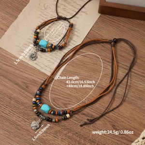 Ethnic style layered necklace with turquoise beads and antique silver pendant on wood