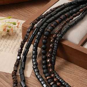 Macro detail of wood and volcanic stone beads on vintage paper and wood tray