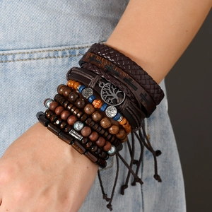 Detail of bohemian layered bracelets with tree of life charm and woven leather