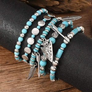 Detail of bohemian turquoise beads and silver charms with feather and arrow pendants