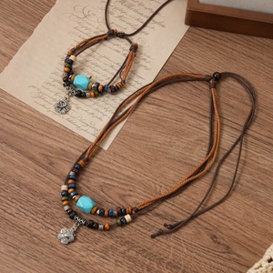 Detail of ethnic double-layered boho necklace with turquoise beads and flower pendant