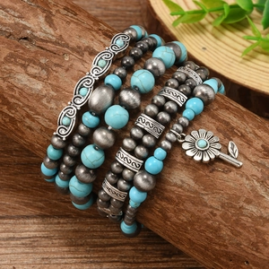 Bohemian multi-layer turquoise bead bracelet with sunflower charm on a wooden branch