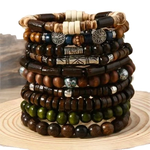 Detail of bohemian multilayer beaded bracelets with wood beads and tree of life charms