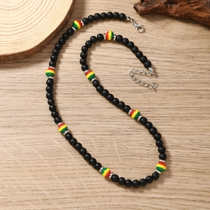 Close-up of Bohemian beaded choker with matte black beads and colorful striped accents