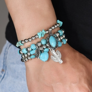 Detail of bohemian turquoise beaded bracelet set with cactus, heart and leaf charms