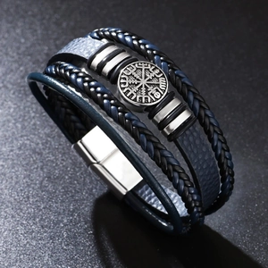 Détail du charm boussole viking sur un bracelet en cuir tressé multicouche avec fermoir