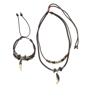 Detailed view of tribal style woven necklace and bracelet set with fang pendants