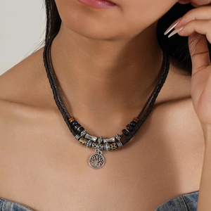 Detail of tree of life pendant on multi-layer woven necklace with wooden beads