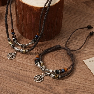 Detail of bohemian woven leather necklace with tree of life pendant and vintage beads