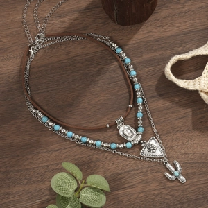 Detailweergave van gelaagde bohemian ketting met turkoois en cactushangers set