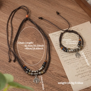 Detail view of vintage multi-layer woven necklace with tree of life pendant on wood