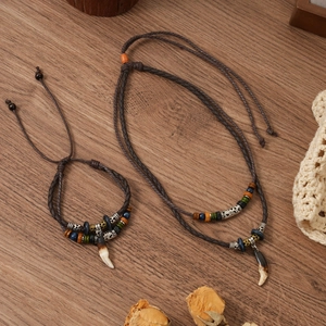 Macro detail of hand-woven ethnic necklace with resin wolf tooth pendant and beads