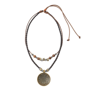 Collier médaillon vintage avec perles ethniques et cordon tressé sur fond blanc pur