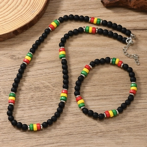 Close-up of bohemian beaded necklace with black, red, yellow and green beads on wood
