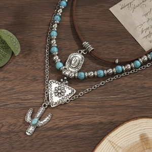 Detailopname van vintage meerlaagse ketting met turquoise kralen en cactus hanger