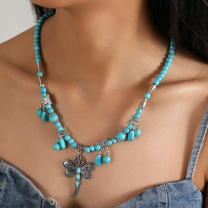 Bohemian turquoise beaded necklace featuring a large dragonfly pendant and butterfly charms