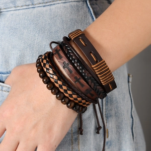 Close-up of bohemian layered leather bracelet featuring wooden beads and cross patterns