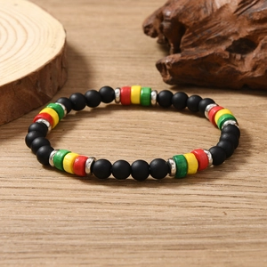 Detail of bohemian handmade beaded bracelet with black matte beads and Rasta color accents