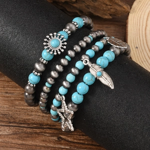 Detail of bohemian turquoise beaded bracelet set with silver feather and star charms