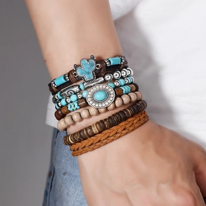 Detail of layered bohemian bracelets with turquoise charms and wooden beads on wrist
