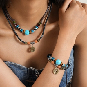 Ethnic layered wolf tooth necklace with turquoise beads and vintage bronze coin pendant