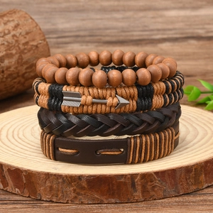 Detail of four-piece vintage bohemian leather bracelet set with arrow charm on wood