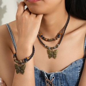 Detail of vintage bohemian layered necklace with butterfly pendant and blue beads