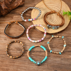 Set of seven bohemian beaded bracelets with turquoise, wood, and leather on wood background