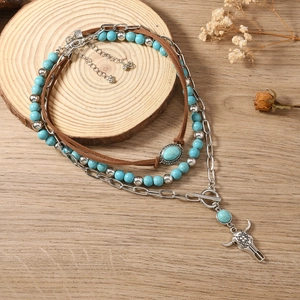 Detail van de boheemse gelaagde ketting met turquoise kralen en vintage stierenkop hanger