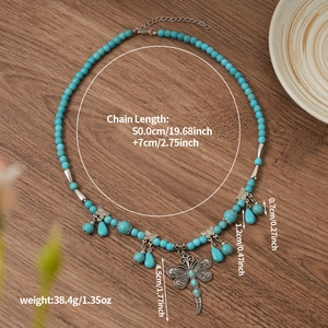 Bohemian turquoise beaded necklace featuring a vintage dragonfly pendant on wood background