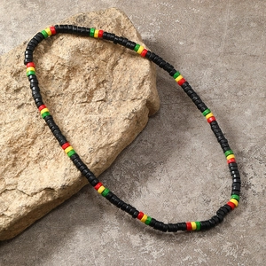 Detail of handmade Rasta style beaded necklace displayed on a natural textured stone