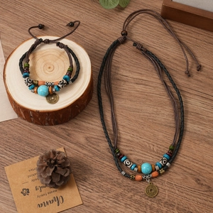 Detailed close-up of ethnic style woven jewelry set with turquoise beads and coins