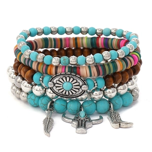 Detalle de set de pulseras bohemias con piedras turquesas y dijes de plumas plateadas