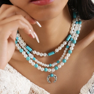 Three-layer bohemian necklace featuring faux pearls, turquoise beads, and a crescent pendant