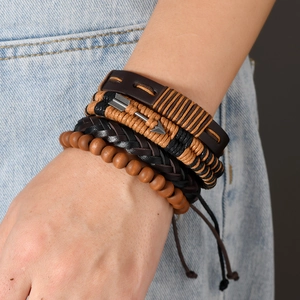 Detail showing multi-layer bohemian leather bracelets with wooden beads on a male wrist
