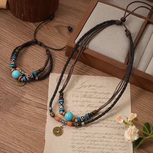 Detailed view of woven ethnic necklace with turquoise beads and retro copper coin pendant