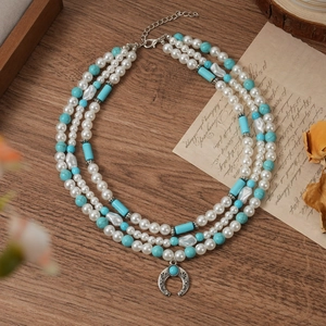 Bohemian multi-layer necklace with faux pearls, turquoise beads, and a horseshoe pendant