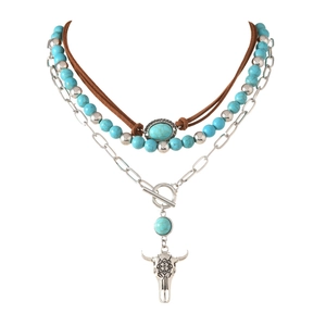 Detail van bohemien gelaagde ketting met zilveren stierenkop hanger en turquoise kralen