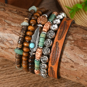 Detail of bohemian multilayer bracelet with wood beads, turquoise, and feather charms
