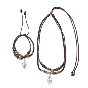 Detail of bohemian multilayer brown cord necklace with wooden beads and silver leaf pendant