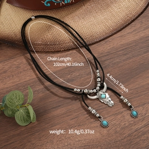 Western bolo tie with bull head skull pendant and turquoise stone on dark wood background