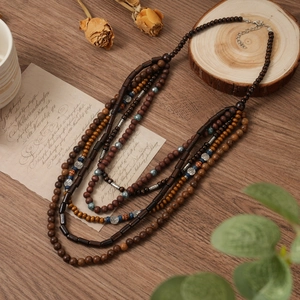 Vue détaillée du collier multicouche en perles de bois avec breloque Arbre de Vie