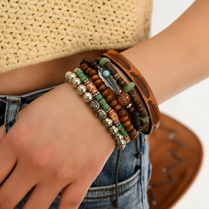 Detail of bohemian multilayer bracelet set with feather charms and wooden beads