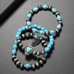 Detail of bohemian turquoise beaded bracelet set with vintage heart pendant and silver accents