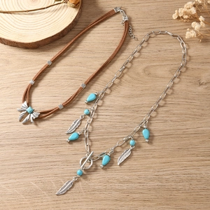 Detail van bohemien kettingset met turquoise kralen, zilveren strik en veerhangers