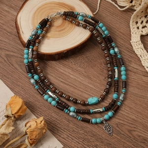 Vue détaillée du collier bohème à trois rangs avec perles en bois et pendentif cœur