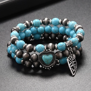 Close-up of Bohemian layered elastic bracelets with turquoise beads and heart charms
