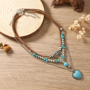 Detail van bohemien hart turquoise hanger met zilveren maan en gelaagde kralenketting