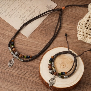 Close-up of ethnic multi-layer woven necklace with wooden beads and leaf pendant