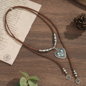 Bohemian double-layer long necklace with heart pendant and turquoise stones on wood